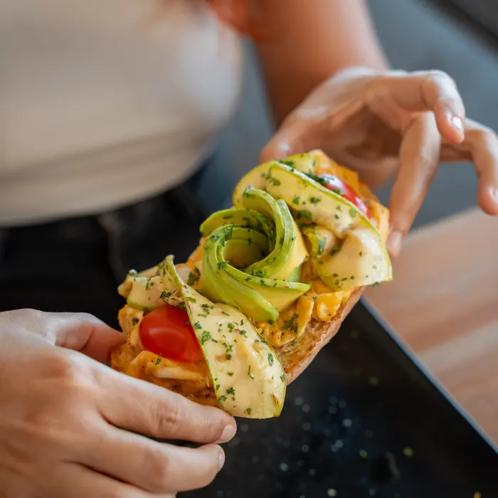 Tostada con aguacate en la mano