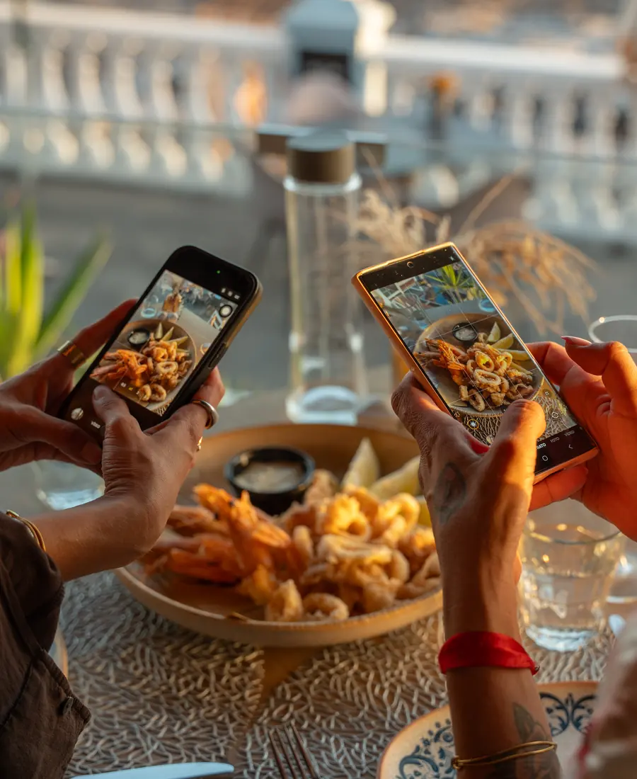 Dos móviles fotografiando el plato en la mesa