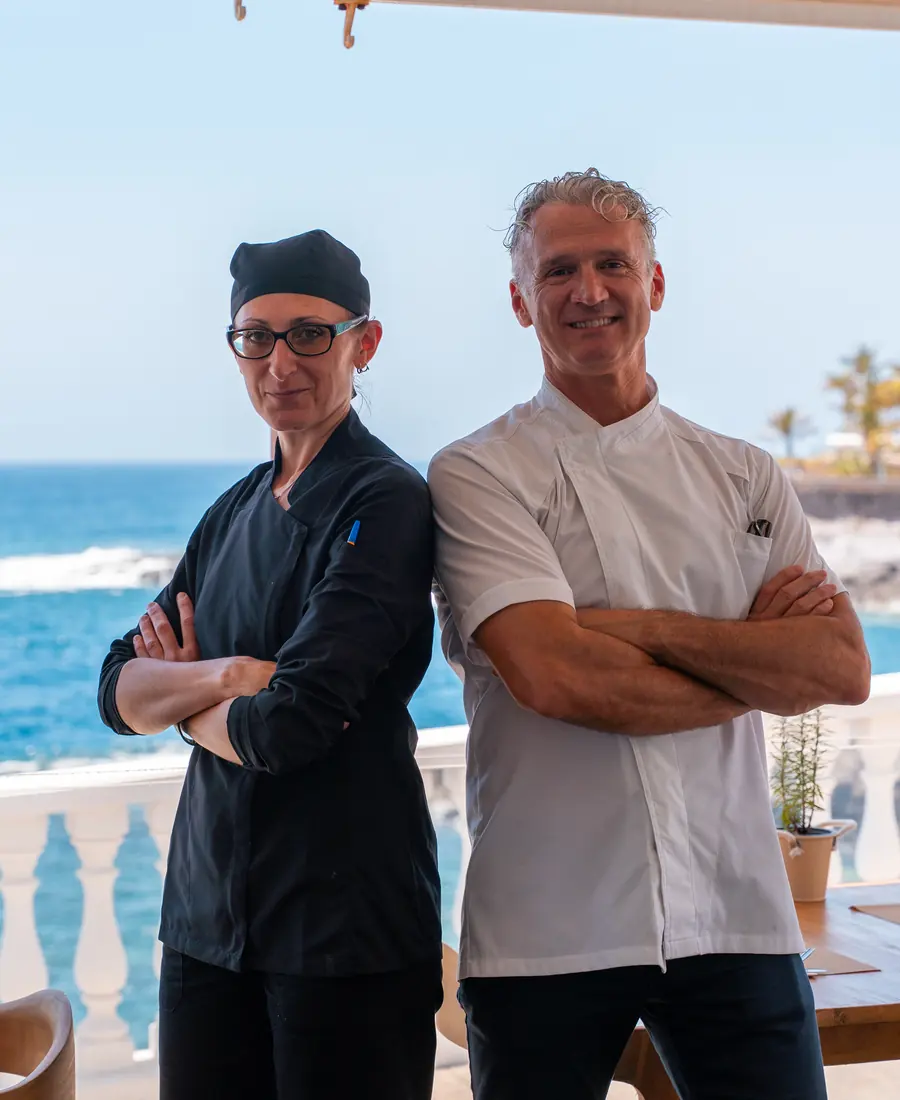 Dos chefs de brazos cruzados frente al mar