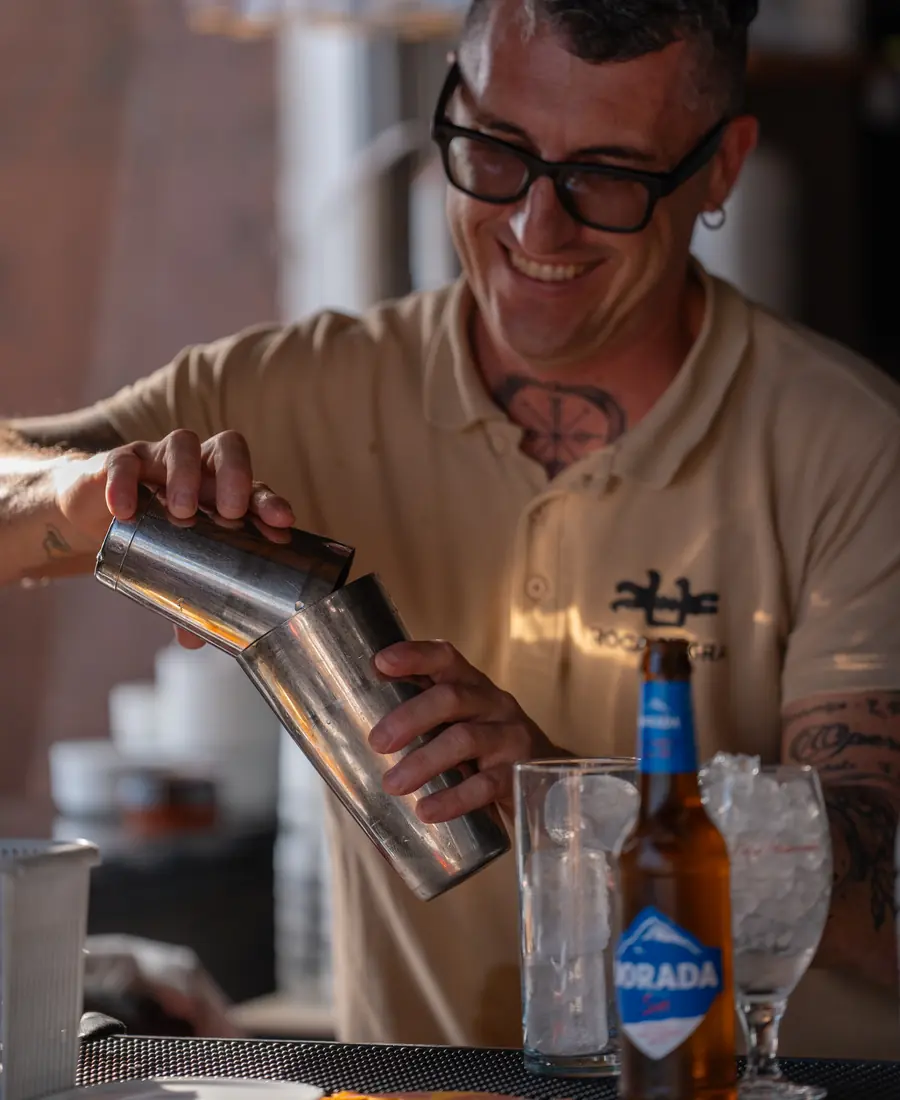 Barman sirviendo un cóctel desde la coctelera